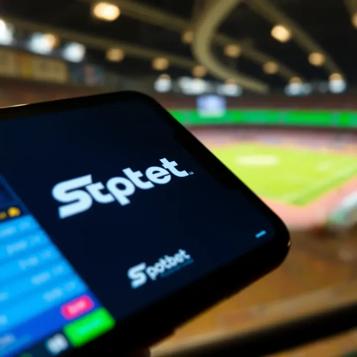 SpotBet logo with digital sports betting interface on a smartphone screen